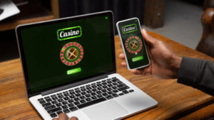 a man is playing online casino on his laptop and mobile phone